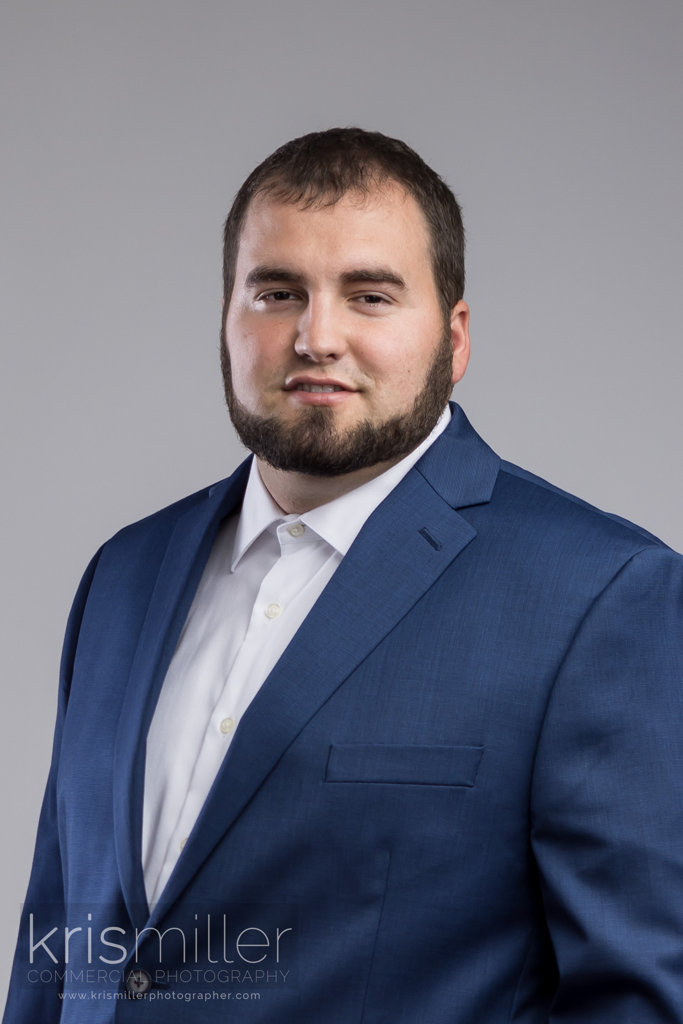 Corporate headshot of a man in a navy blazer